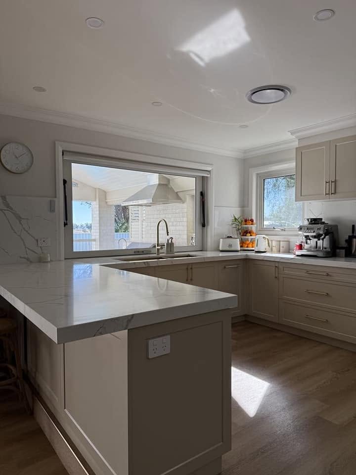 A custom kitchen with window splashback and stone benchtops