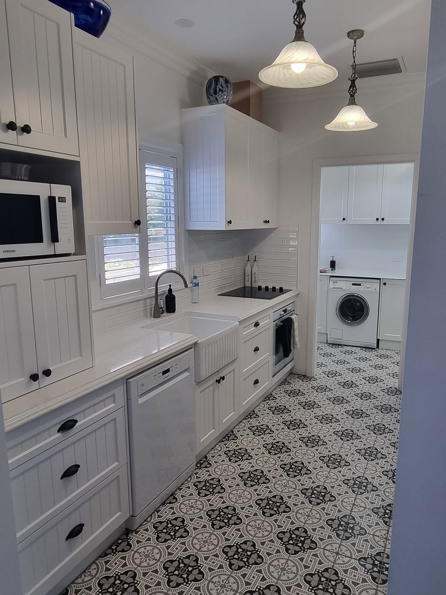 A country-style kitchen and laundry with patterned tile floor