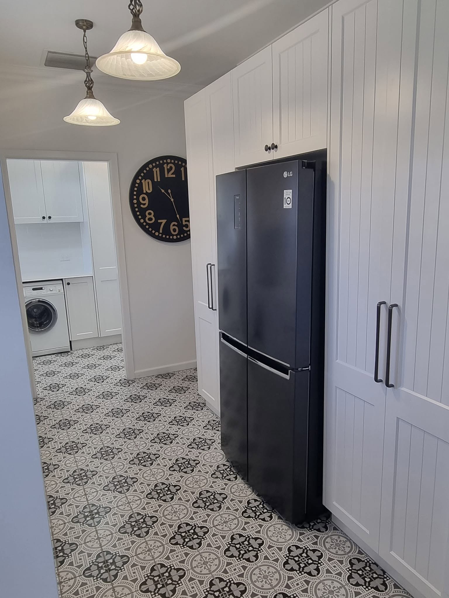 Custom kitchen cabinetry around a black fridge