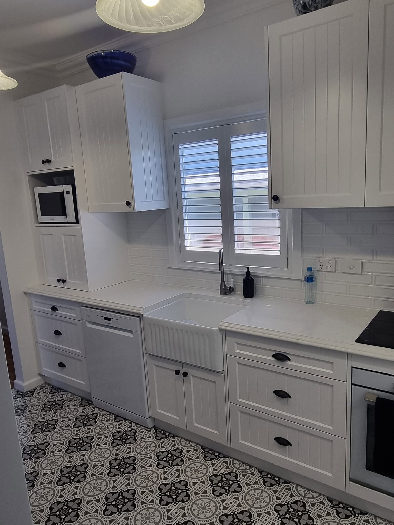 A custom kitchen sink run with farmhouse sink and stone benchtop