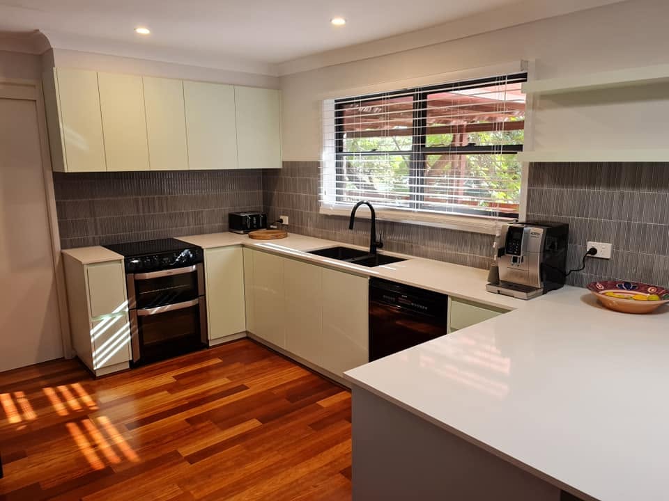 A renovated kitchen with new benchtops and cabinetry over timber floors